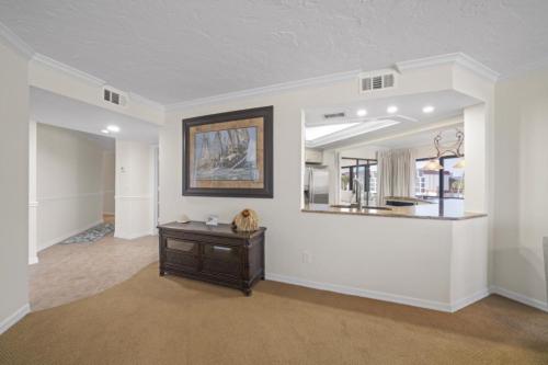 a living room with a table and a mirror at Pointe Santo A24 condo in Sanibel