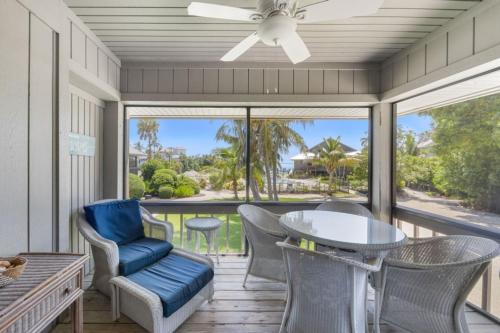 a screened porch with a table and chairs and a ceiling fan at Ventura Captiva 2B condo in Captiva