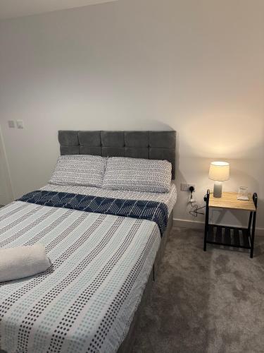 a bedroom with a bed and a table with a lamp at Large Room, 10 Min to Station in Sittingbourne