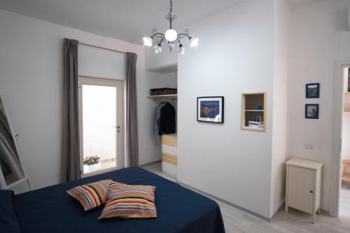 a bedroom with a blue bed with a pillow on it at Pioppi Apartments in Pioppi