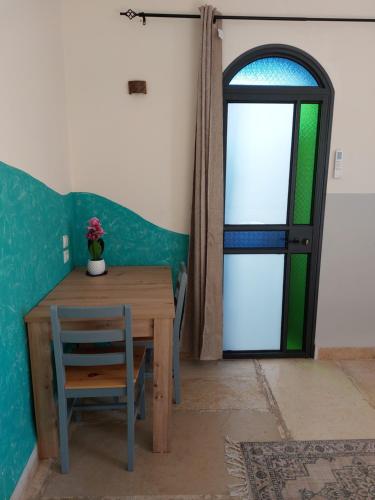 a table and a chair and a door with a window at The Essence Tzimer in Safed