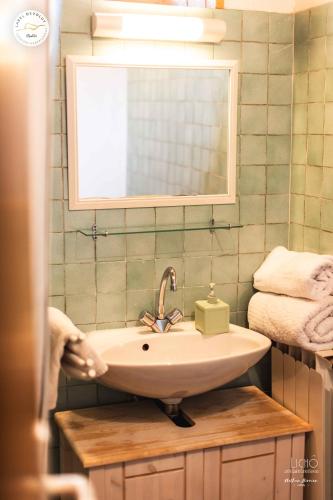 a bathroom with a sink and a mirror and towels at Gîte et chambres d'hôtes "La Tourtette" 12 pers in Le Dévoluy