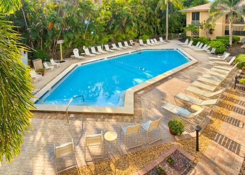 a large swimming pool with chairs at Coquina Beach 1F condo in Sanibel