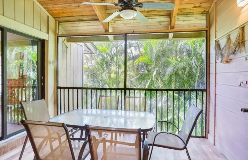 a dining room with a table and chairs on a balcony at Coquina Beach 1F condo in Sanibel