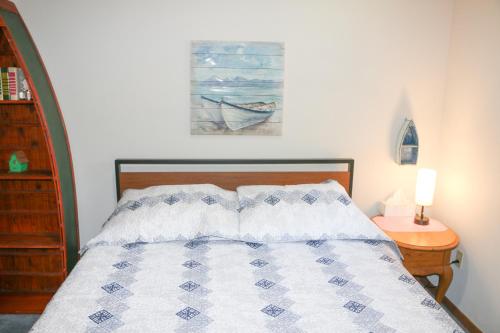 a bedroom with a bed with a blue and white quilt at Fishermens Paradise with Fire Pit on Rice Lake! in Rice Lake