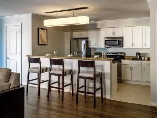 a kitchen with a bar with four chairs around it at Hyatt Regency Clearwater Beach Resort & Spa in Clearwater Beach
