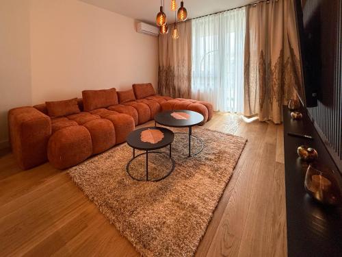 a living room with a couch and two tables at BW Crown Garden Residences in Sajmište