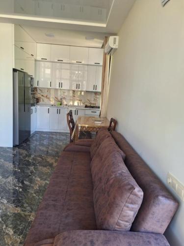 a large brown couch in a room with a table at LIFE GUARD ქობულეთი in K'obulet'i