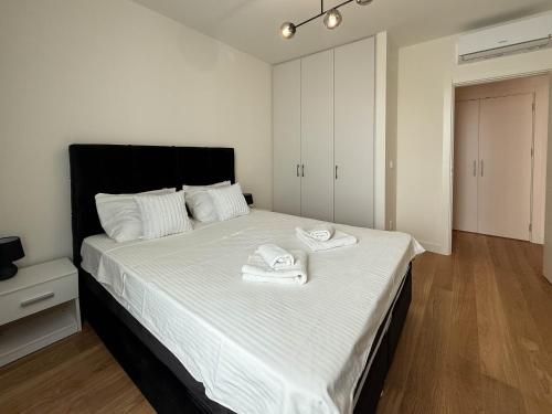 a bedroom with a large bed with towels on it at BW Crown Garden Residences in Sajmište