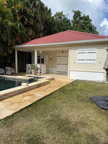 a house with a swimming pool in front of it at Petite Maison Contemporaine in Rivière-Salée