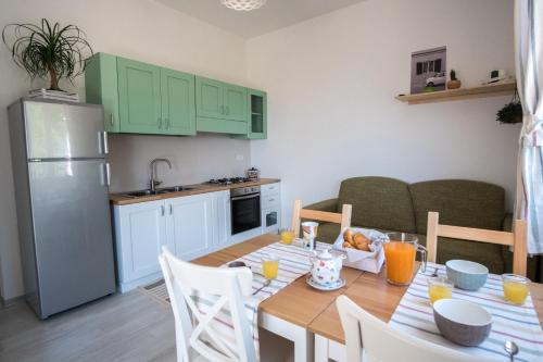 a kitchen and a dining room with a table and a refrigerator at Pioppi Apartments in Pioppi