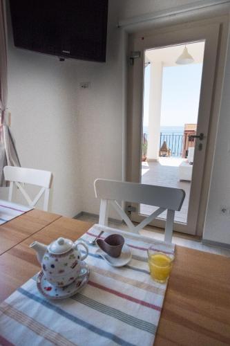 a tea set on a table in a kitchen with a view at Pioppi Apartments in Pioppi