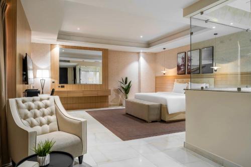 a hotel room with a bed and a chair at George Residence TLC in Lekki