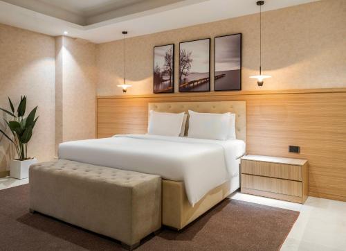 a bedroom with a large white bed and a ottoman at George Residence TLC in Lekki