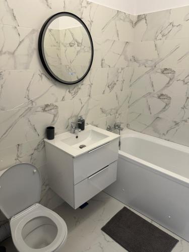 a white bathroom with a sink and a mirror at Atlantis Suites Bragadiru Bucuresti Parcare gratuita Self checkin in Bragadiru