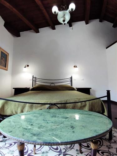 Un dormitorio con una cama y una mesa de cristal. en Uiza de San Pé, en Carloforte