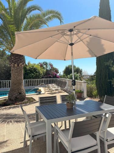 a table with an umbrella next to a pool at B5 Villa Sueños in Santo Tomás
