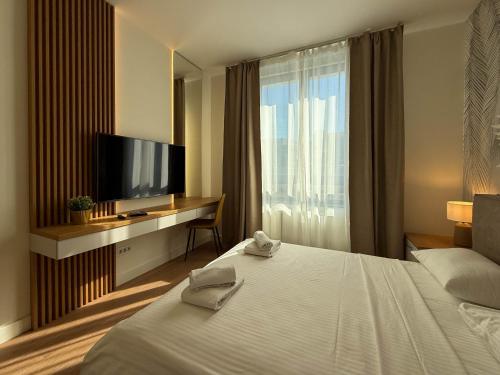 a hotel room with a bed and a flat screen tv at BW Crown Garden Residences in Sajmište