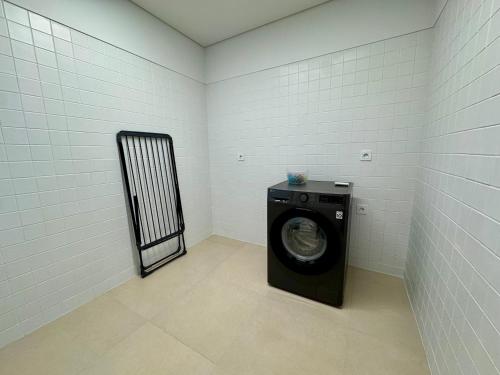 a laundry room with a washing machine in it at Green Coast Apartments in Capelas