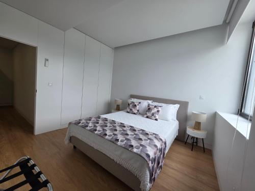 a bedroom with a bed in a white room at Green Coast Apartments in Capelas