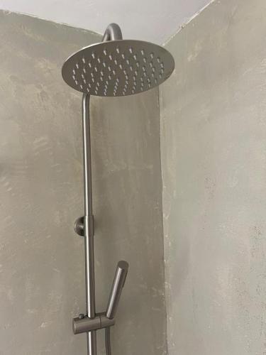 La salle de bains est pourvue d'un pommeau de douche mural. dans l'établissement Seaview Oasis and Relaxation, à Paralia Dionisiou