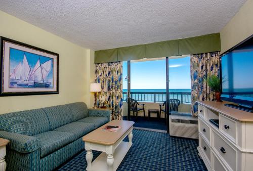 a living room with a couch and a flat screen tv at Compass Cove in Myrtle Beach