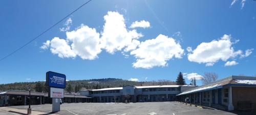 a parking lot in front of a building with clouds in the sky at Americas Best Value Inn-Williams/Grand Canyon in Williams