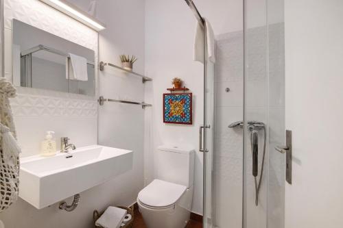 a bathroom with a toilet and a sink and a shower at Casa Soalheira - Tavira Center in Tavira