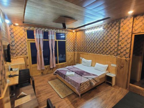 a bedroom with a bed in a room with wooden walls at Hotel HiLL Mount View Dalhousie Chamba in Dalhousie