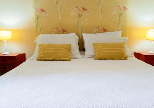 a bedroom with a white bed with two yellow pillows at Moreno 820 by DOT Suites in Buenos Aires