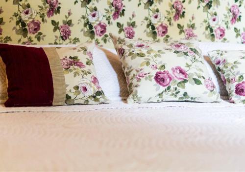 a bed with three pillows and a floral wall at Moreno 820 by DOT Suites in Buenos Aires