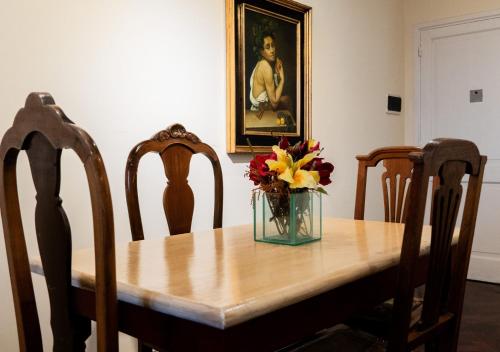 a dining room table with a vase of flowers on it at Moreno 820 by DOT Suites in Buenos Aires