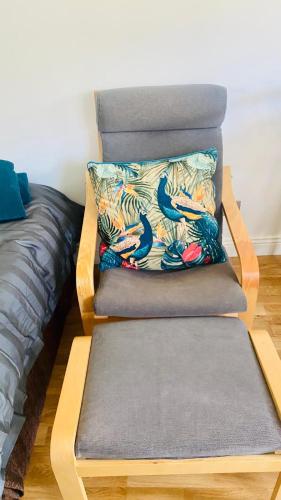 a chair with a pillow on it next to a bed at Cherry Hill Studio in Caversham