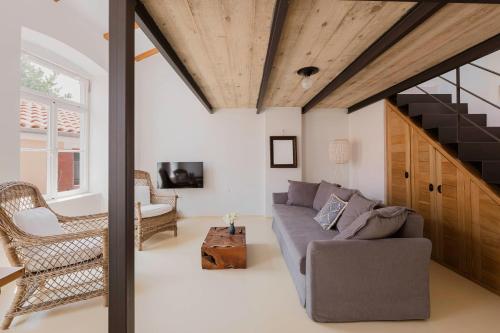 a living room with a couch and a staircase at Apartments Argemonia in Mali Lošinj