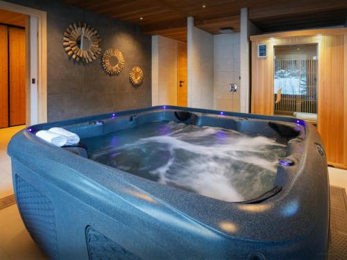 un bagno con grande vasca blu di Chalet Julero - OVO Network a Le Grand-Bornand