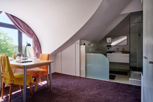 an attic kitchen with a table and yellow chairs at La Petite Bruyere De Renaix in Ronse
