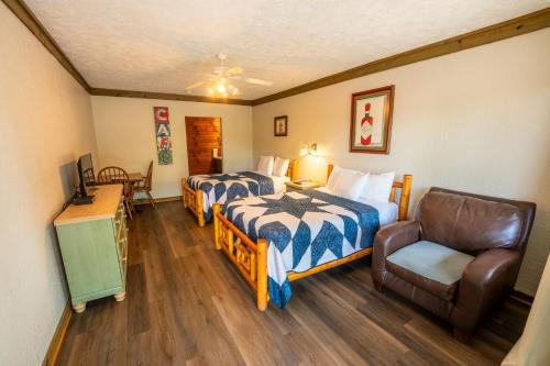 a hotel room with two beds and a chair at Fishtale Lodge in Buchanan