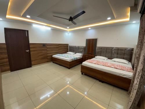 a bedroom with two beds and a ceiling at Hotel Lala Ji in Nīthrāna