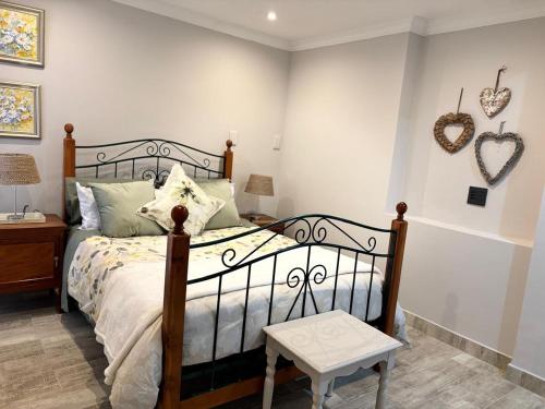 a bedroom with a bed and a table and hearts on the wall at Casa Madeira 1 in Gillitts