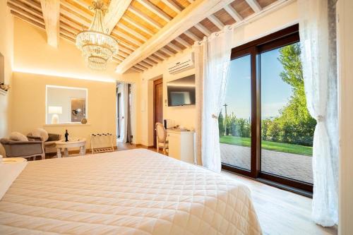 a bedroom with a large bed and a large window at Boutique Hotel Masolino in Panicale