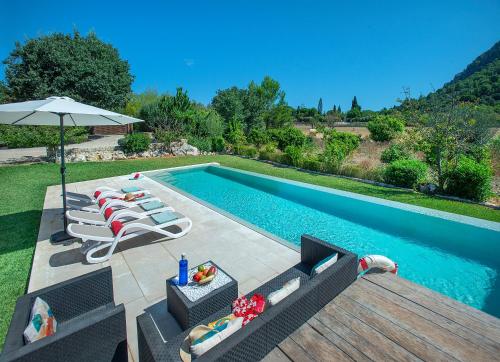 une piscine avec des chaises longues et un parasol dans l'établissement Owl Booking Villa La Rafal - Luxury Retreat with Mountain Views, à El Port