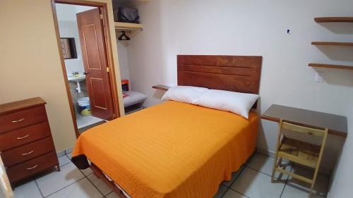 a bedroom with a bed and a desk and a mirror at Posada "CASA BONITA" in La Cal