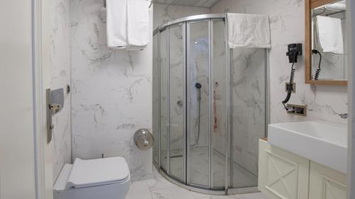 a bathroom with a shower and a toilet and a sink at ADIYAMAN PARK HOTEL in Adıyaman