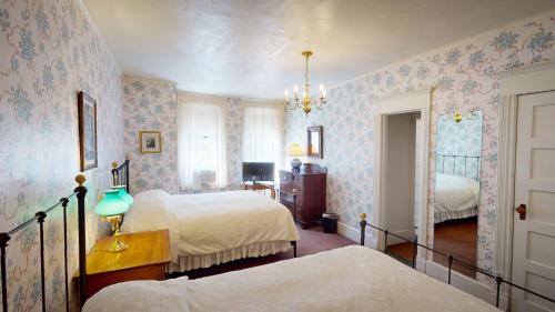 a bedroom with two beds and floral wallpaper at The Red Lion Inn in Stockbridge