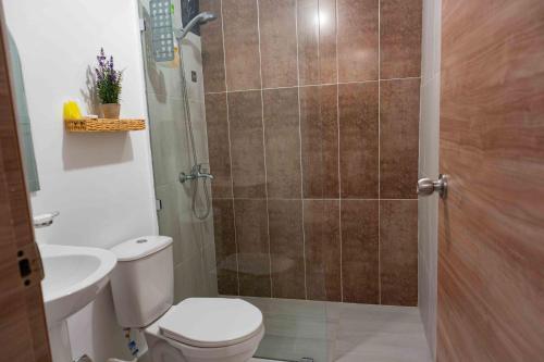 a bathroom with a shower with a toilet and a sink at 2 Bedrooms at Baia Residences in Santiago de los Caballeros