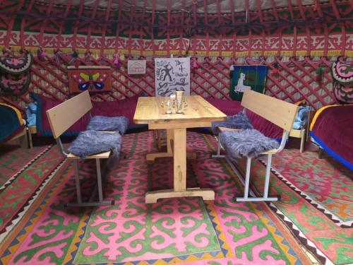 a table and two chairs in a room at Anarbek's Yurt Camp in Kol-Suu
