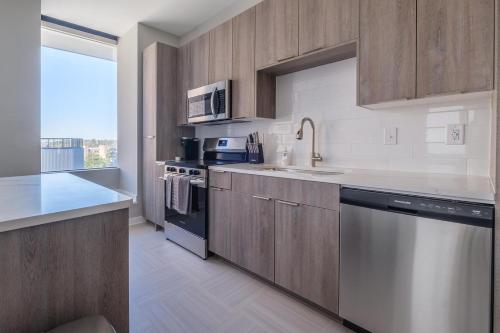 a kitchen with wooden cabinets and stainless steel appliances at Landing at The 600 - Birmingham in Birmingham