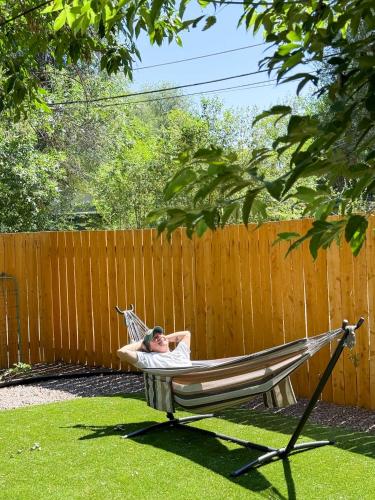 a woman laying in a hammock in a yard at Cargo Casita Shipping Container Tiny Home in Colorado Springs