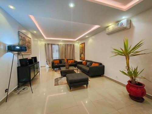 a living room with two couches and a camera at Le spacieux bord de mer in Dakan