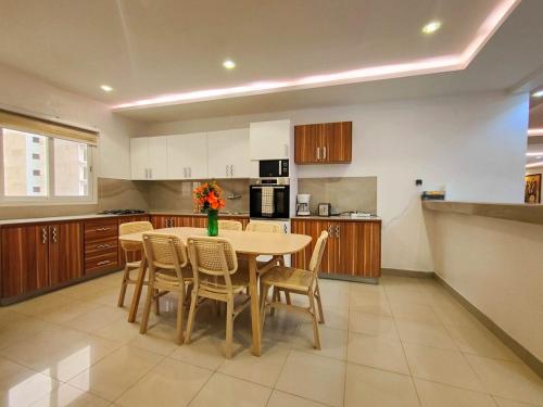 a kitchen with a table and chairs in it at Le spacieux bord de mer in Dakan